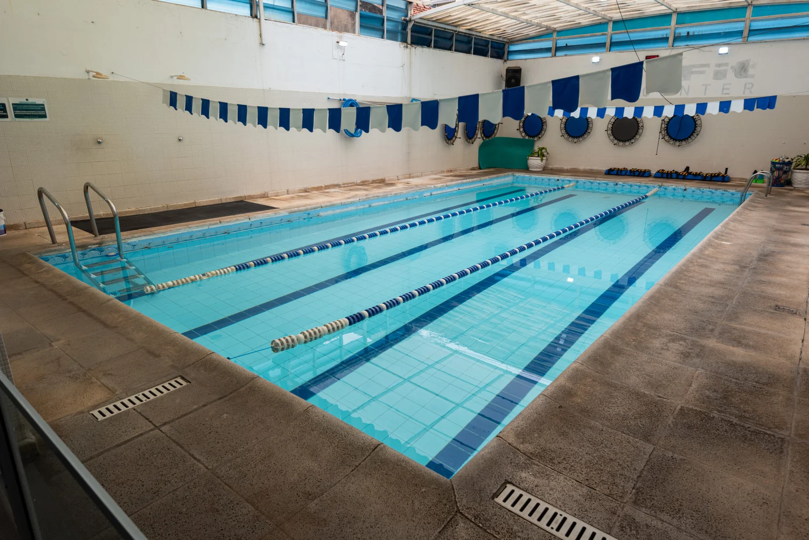Piscina coberta da MaxFit com raias e água azul.